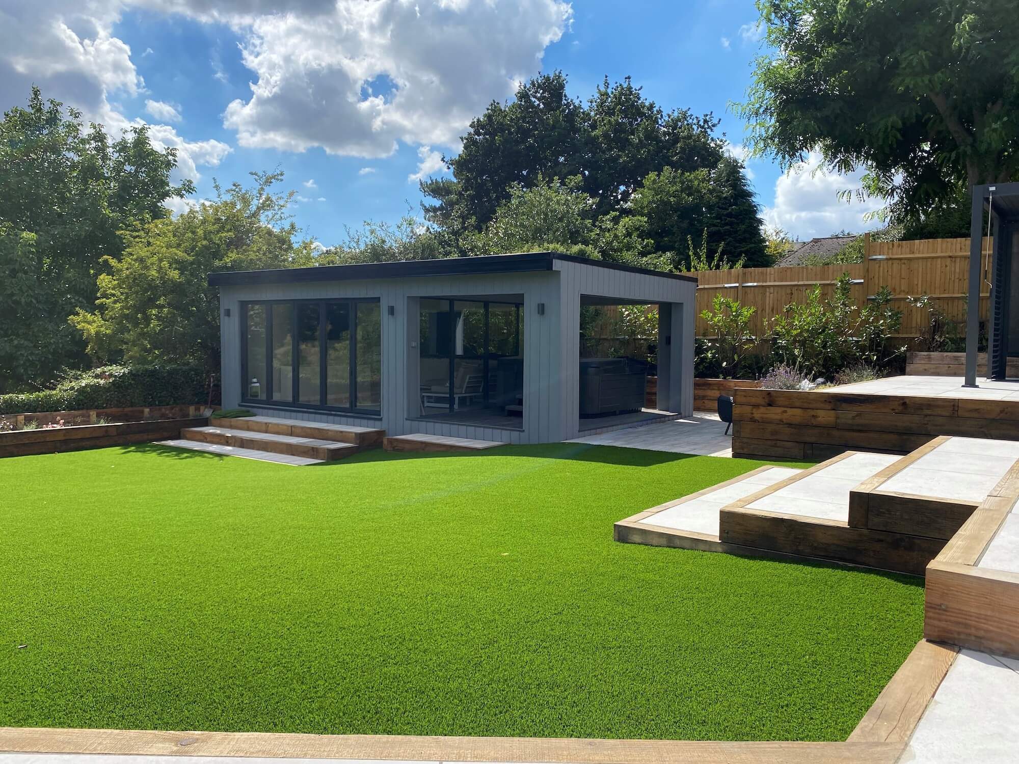 Premium artificial lawn in back garden with garden pod